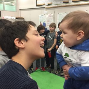 A boy and a baby interact.