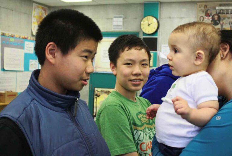 Older Boy locks eyes with Roots of Empathy Tiny Teacher (Baby)